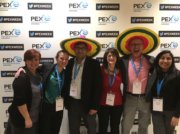 people posing in front of Pex Awards wall, two people have sombreros