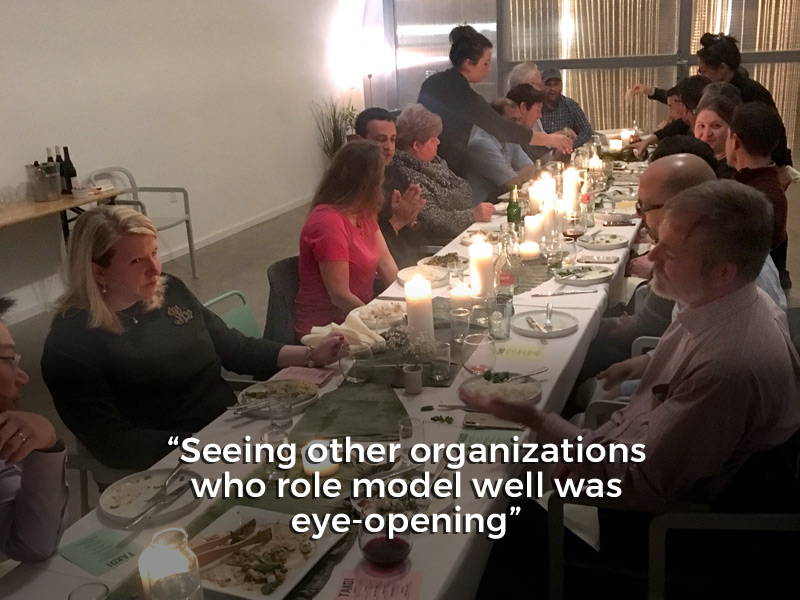 Several people sitting having dinner and talking, with quote at bottom saying 'Seeing other organizations who role model well was eye-opening'