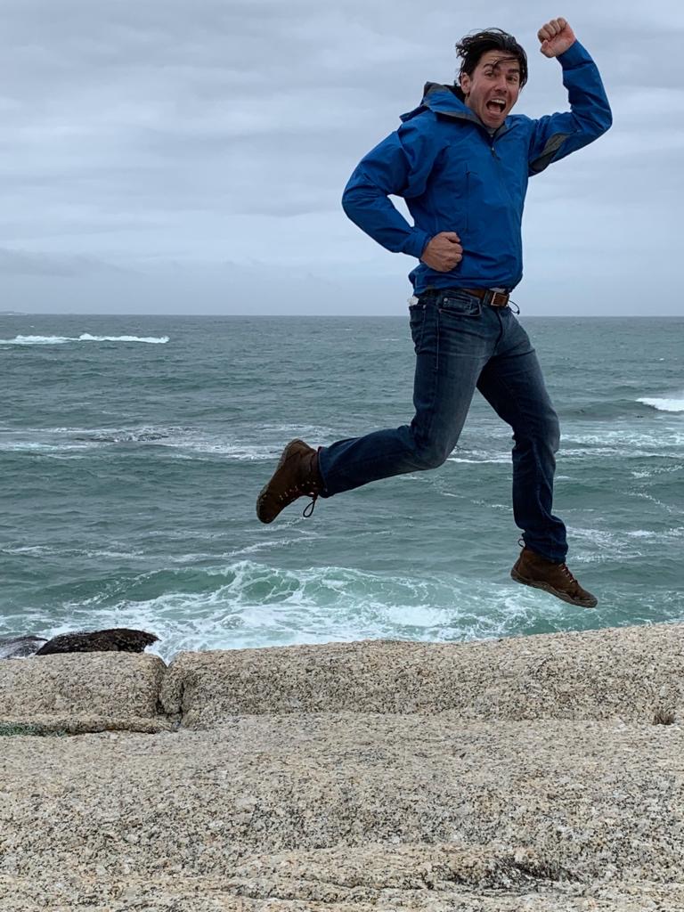 person jumping in air next to ocean