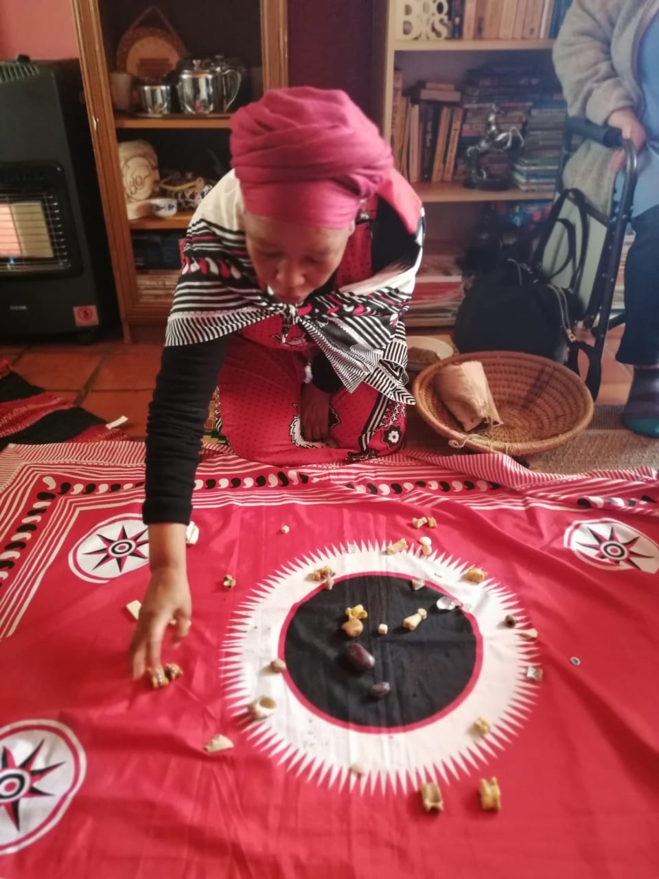 person reaching for small items on an elaborate red rug